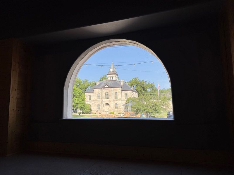 The 1893 Somervell County Courthouse seen through the Palace's arched second-floor window