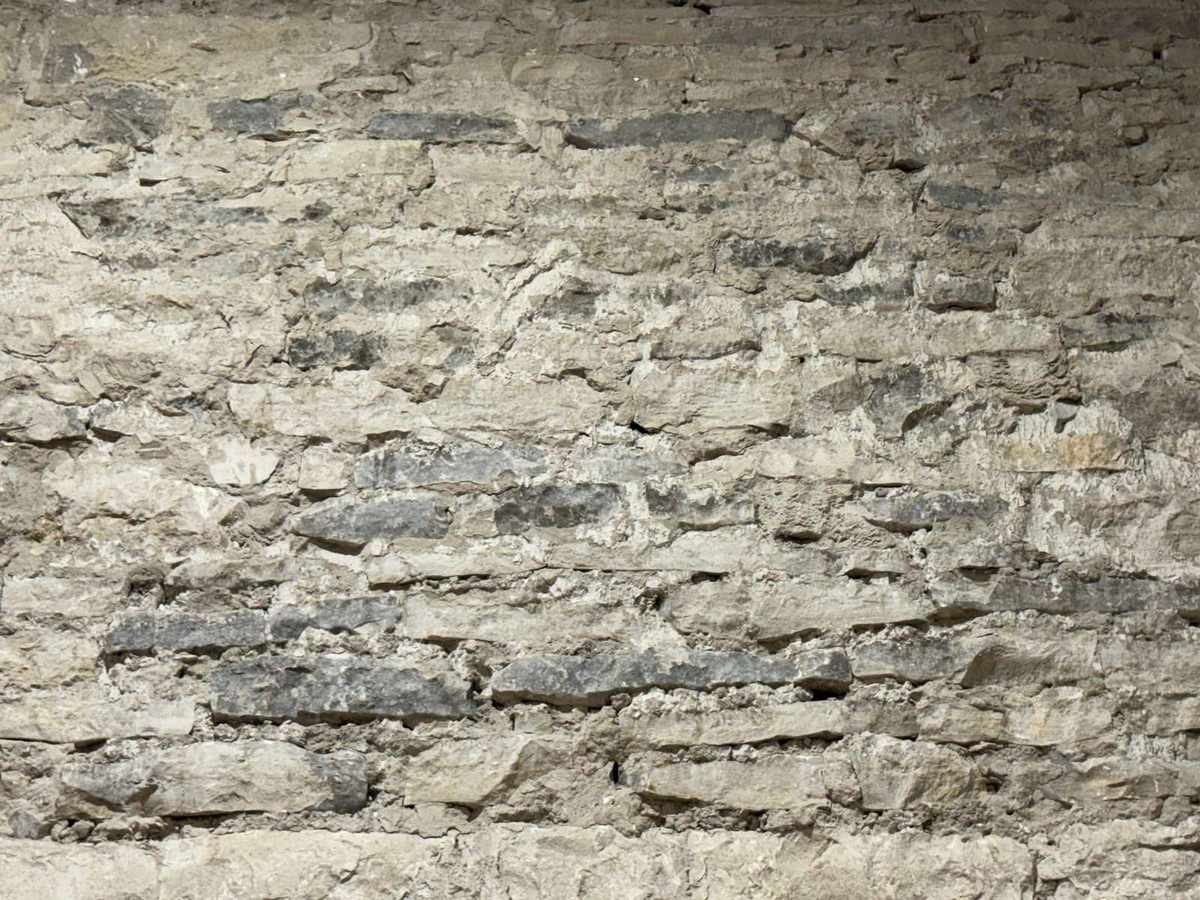 Close-up of the original rough-cut limestone wall in warm raking light